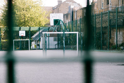 Empty basketball court seen through fence