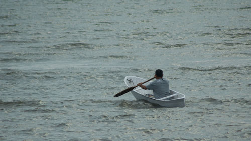 Rear view of man sitting at beach