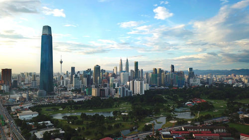 Aerial view of buildings in city against sky