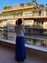 Rear view of woman standing against building