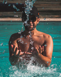 Shirtless man swimming in water