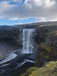 Scenic view of waterfall against sky