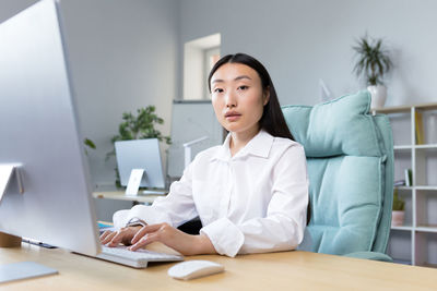 Portrait of young businesswoman using laptop at home