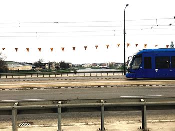 Train on railroad track in city against sky