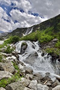 Scenic view of waterfall against sky