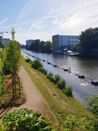 Scenic view of river by buildings against sky