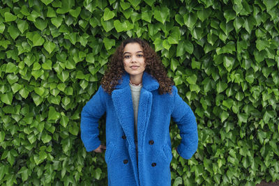 Portrait of woman standing against plants