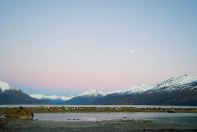 Scenic view of lake and mountains against sky during winter