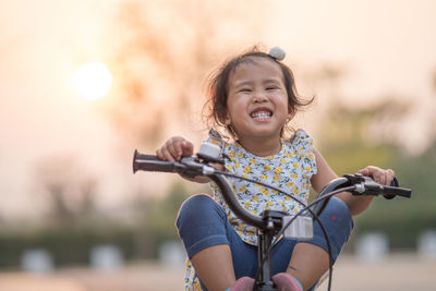 Happy little girl ride a bicycle in the park