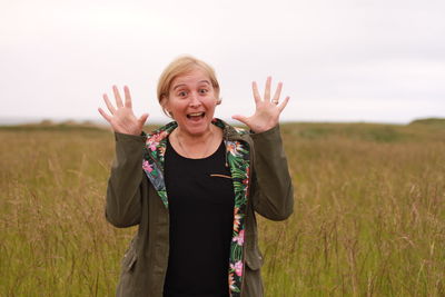 Portrait of a smiling young woman standing on field