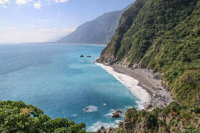 Scenic view of sea and mountains against sky