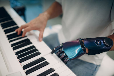 Midsection of man playing piano