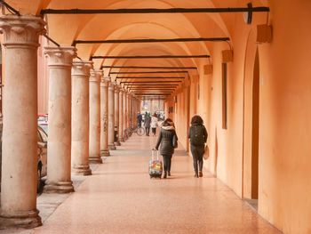 Rear view of people walking in corridor of building