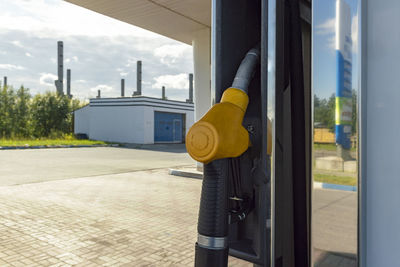 Close-up of yellow pole by street against sky