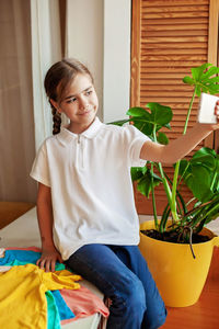 Girl in white t-shirt makes photo with smartphone. mockup friendly. t-shirts ready to have design