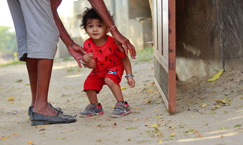 Trying to raise a little boy of indian origin by holding grandpa, india.