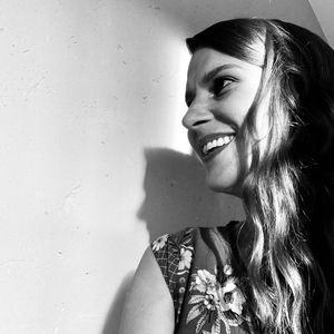 Portrait of smiling young woman against wall