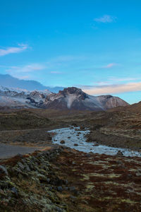 Scenic view of snowcapped mountains against blue sky