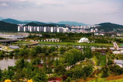 High angle view of townscape by lake against sky