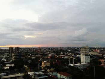 Cityscape against cloudy sky