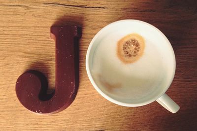 High angle view of coffee cup on wooden table