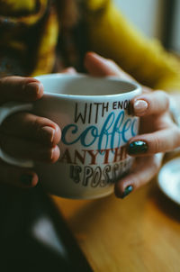 Cropped image of hand holding coffee cup