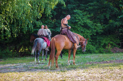 Horses riding horse in a field