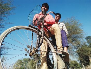 Low angle view of man riding bicycle against sky