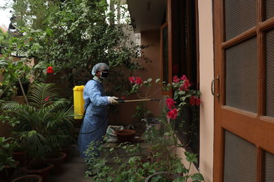 Full length of man sanitizing home