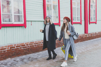 Portrait of smiling couple standing against building