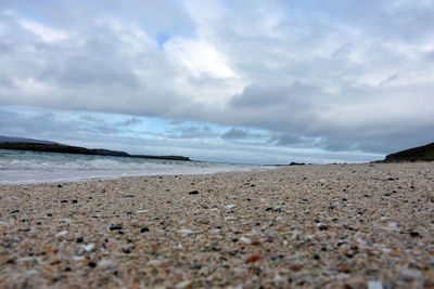 Scenic view of beach against cloudy sky