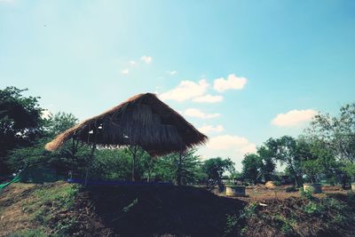 Houses by trees against sky