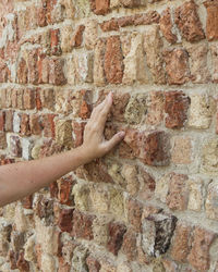 Human hand on brick wall
