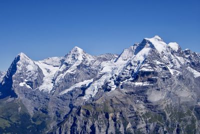 Snowcapped mountains against clear blue sky