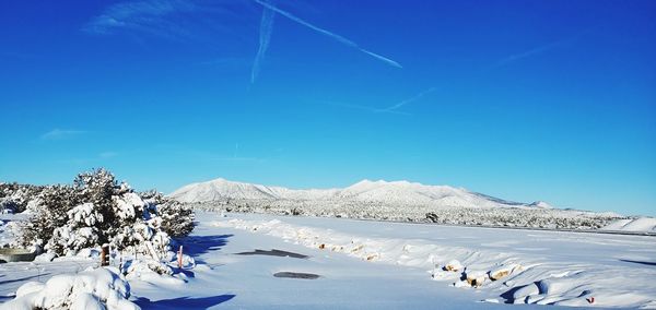 Scenic view of snowcapped mountains against clear blue sky