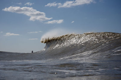 Waves splashing in sea against sky