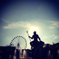 Silhouette of ferris wheel against sky