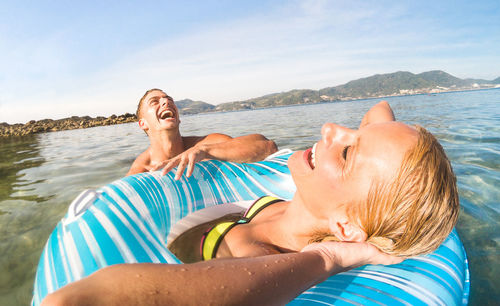 Happy friends enjoying in water at beach