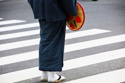 Low section of person in traditional clothing standing on road