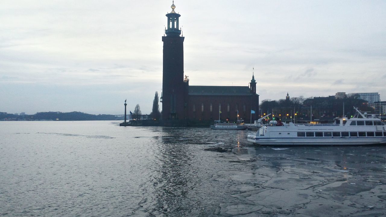 water, built structure, architecture, sky, building exterior, sea, nautical vessel, lighthouse, transportation, waterfront, cloud - sky, mode of transport, boat, pier, guidance, nature, cloudy, harbor, outdoors, day