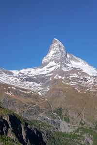 Scenic view of snowcapped mountains against clear blue sky