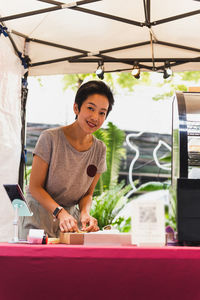 Woman small business owner packing box on table delivery to customer.