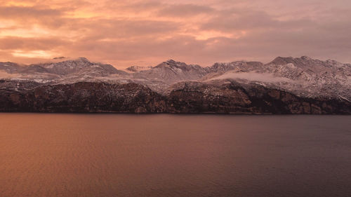 Scenic view of snowcapped mountains against sky during sunset