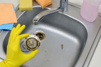 Cropped image of person cleaning sink