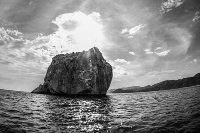 Rock formation in sea against sky