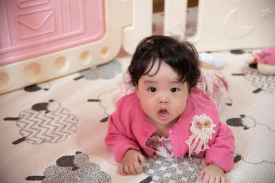 Portrait of cute girl in crib at home