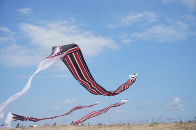 Low angle view of kites flying against sky