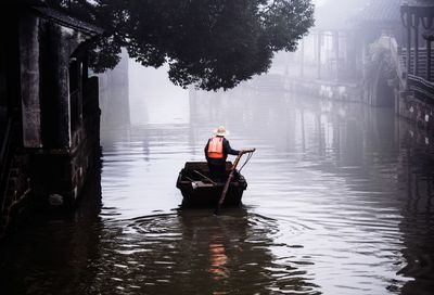 Man sitting on boat in river