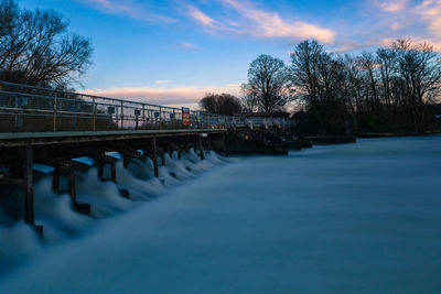 Bridge over canal against sky during sunset