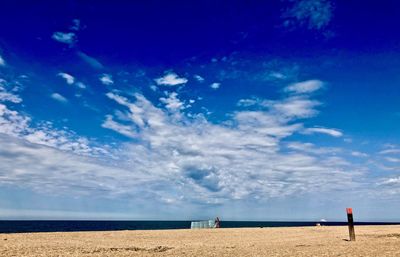 Scenic view of beach against blue sky